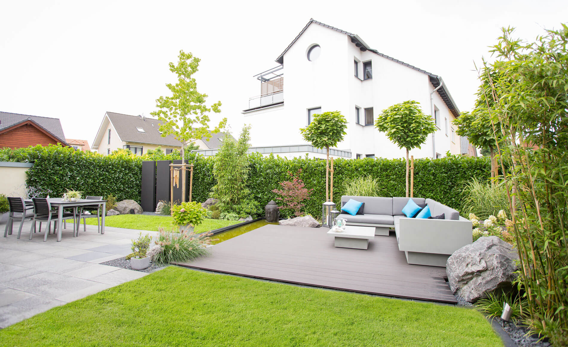 Ein schön angelegter großer Garten mit einem WPC-Deck für Lounge Möbel.