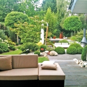 Loungecouch im Garten mit Blick auf ein sehr gelungenes Gartendesign.