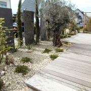 Mediteranes Flair auf einer Terrasse aus Holzdielen in einem mediterranem Garten mit Zypressen und Olivenbaum geplant und gebaut von Wilczek Gärten Siegburg und Hennef