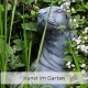 Kunst im Garten in Form eines Seehund aus Stein, der zwischen hohem Gars hervorrschaut.